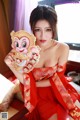 A woman in a red dress holding a monkey.