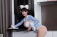 A woman in a bunny costume is posing in the kitchen.