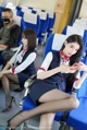 A woman sitting on a train looking at her cell phone.