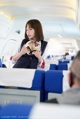 A woman in a business suit is sitting in an airplane.