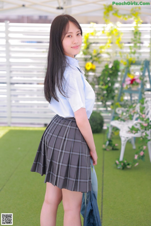 A young woman in a school uniform posing for a picture.