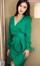 A woman in a green dress posing for a picture.