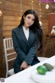 A woman sitting at a table with a plate of fruit.