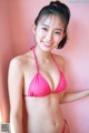 A woman in a pink bikini posing for a picture.