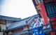 A woman in a blue and white outfit standing on a balcony.