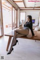 A woman sitting on top of a wooden table.