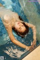 A naked woman floating in a swimming pool.