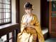 A woman in a yellow kimono sitting on a window sill.