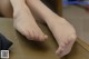 A woman's bare feet sitting on a wooden table.