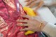 A person holding a banana on top of a red bag.