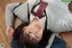 A young woman laying on the floor wearing a school uniform.