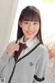 A young woman in a school uniform posing for a picture.